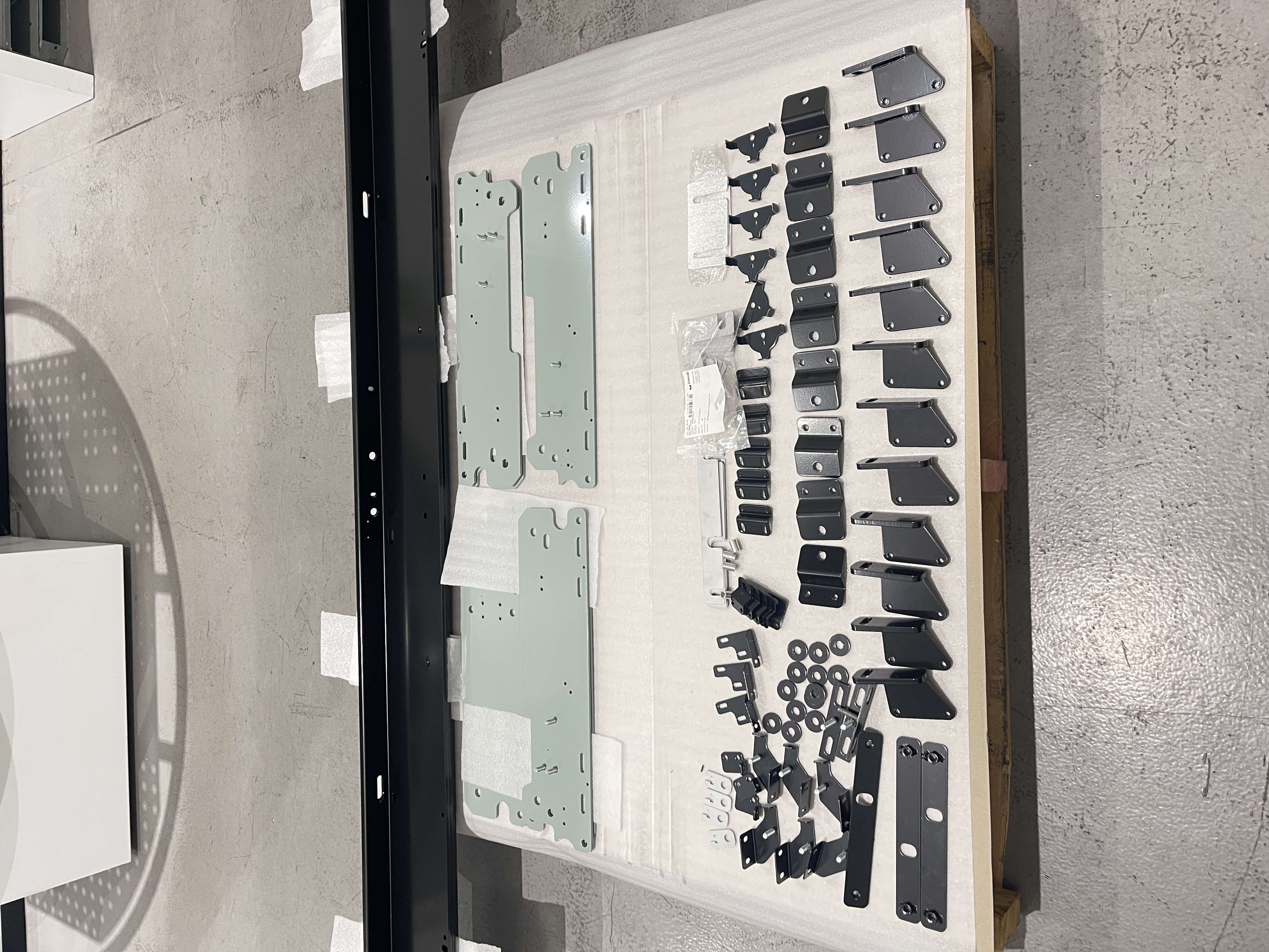 OPIE Manufacturing Group fabricated metal components and powder-coated brackets laid out for assembly